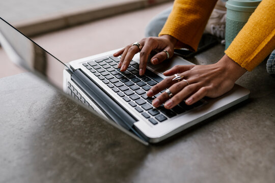 Woman working on laptop while sitting on floor