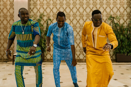 Smiling friends dancing while standing in banquet