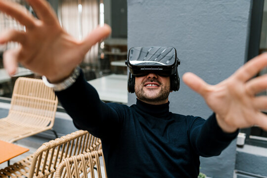 Businessman using virtual reality headset while sitting at cafe