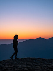 Girl walking on mountains at sunrise in mountains