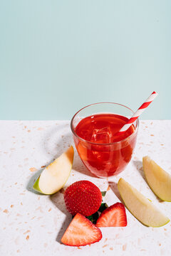 Healthy summer fruit juice with strawberry and apple on modern terrazzo marble against wall