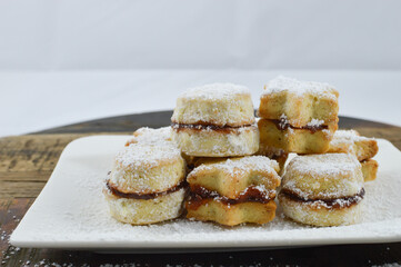 Traditional Serbian homemade sugar powered vanilla cookies with jam (vanilice) round and star shape, selective focus, close up