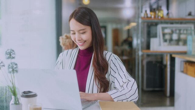 young attractive asian female wear casual cloth hand use smartphone and laptop device comminication social contact in cafe restaruant sit at counter next to big window daylight