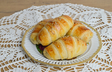 Traditional Serbian  homemade rolls with sesame (kiflice) on the vintage plate, on the rustic...