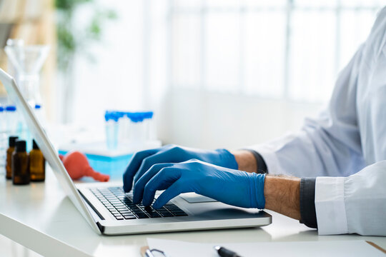 Male scientist working on laptop in laboratory