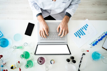 Male scientist making strategies on laptop in laboratory