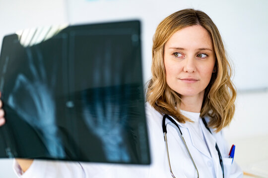 Female radiologist examining X-ray in medical clinic
