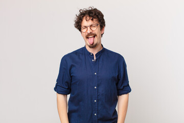 young handsome man with cheerful and rebellious attitude, joking and sticking tongue out