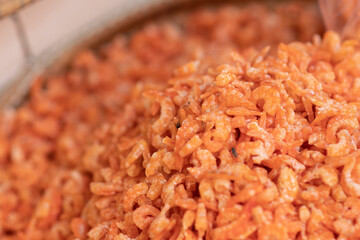 An image of dried shrimp, stacked on a tray and blurred the background.