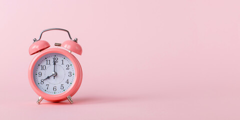 Pink alarm clock on a pink background. Copy space.
