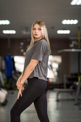 Portrait of a young beautiful athletic blonde in the fitness room.