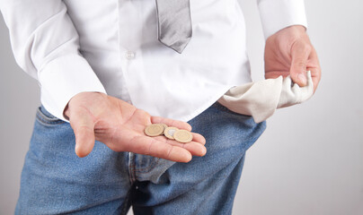 Man with a empty pocket showing coins.