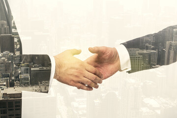 Double exposure of handshake two businessmen on modern skyscrapers background, research and...