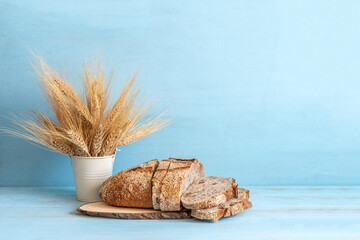 Wheat ears and bread for Jewish holiday Shavuot, for Harvest on blue wooden background with copy...