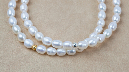 Luxury elegant baroque pearl bracelets on beige textured leather background