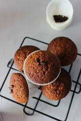 Chocolate muffins in paper forms on a gray background