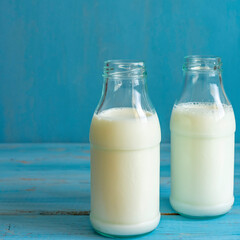 Milk bottle on blue wooden background. Ingredients for cooking. Dairy products.