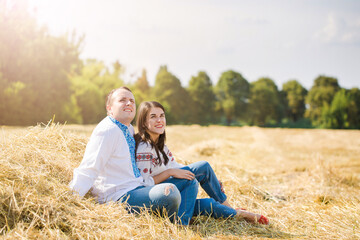 Naklejka na ściany i meble Young couple in the hay in Ukrainian shirts