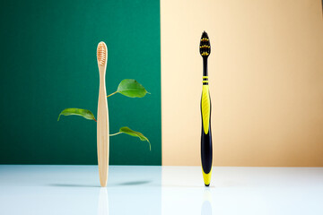 Zero waste, Eco-friendly creative concept. Wooden bamboo toothbrush with leaves VS plastic brush. Natural organic bathroom beauty product.