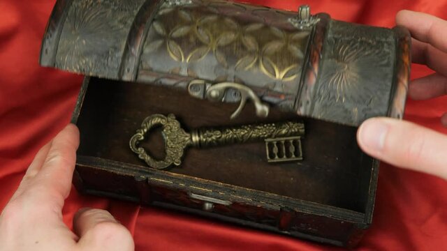 Opening a treasure chest with a key inside, inscription on the key spells "veritas" (truth)