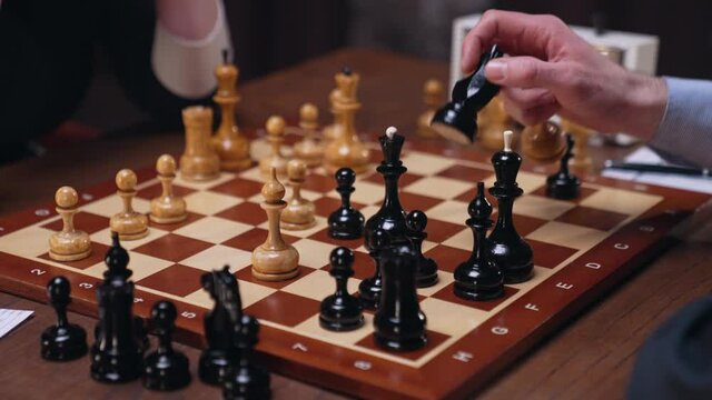 Two chess players man and woman play chess. Debut Accepted Queen's Gambit, King's Gambit, Philidor's Defense. Cinematic filming of a chess game. Antique chess board. This shot can be used for films