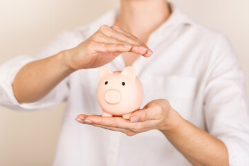 Obraz na płótnie Canvas Piggy bank in hand on light background, space for text. Finance, saving money. Business to success and saving for retirement concept