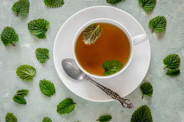 Fresh lemon balm tea in a white cup.