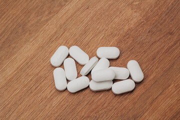 Fototapeta na wymiar Big white pills on wooden background 