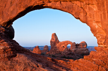 Sunrise lighting Window and Turret Arch in Arches National Park.