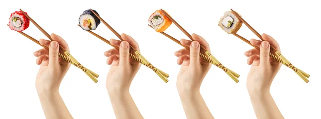 Tuinposter Women's hands hold sushi rolls with sticks. White background. Creative concept. Clipping path. © SOLOTU