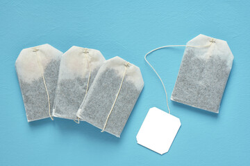 Four tea bag and white label, on a blue background, top view, close up - 432014045
