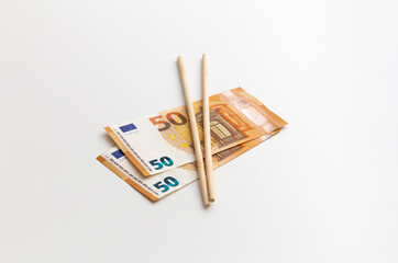 Chinese sticks are on euro banknotes, made of wood, production, white background