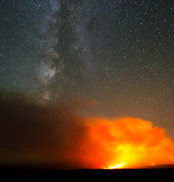 The Alpine Lake Wildfire burns under a clear night sky and Milky Way Galaxy near Lander, Wyoming.