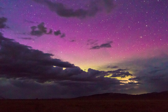 The northern lights glow above the Gros Ventre Mountains, seen from Antelope Flats in Grand Teton National Park, Wyoming.