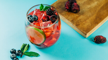 blackberry cocktail with ice, lemon and mint leaf