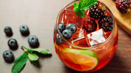 blackberry cocktail with ice, lemon and mint leaf