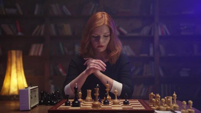 Two chess players man and woman play chess. Debut Accepted Queen's Gambit, King's Gambit, Philidor's Defense. Cinematic filming of a chess game. Antique chess board. This shot can be used for films.