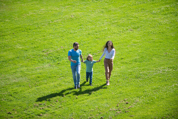 Happy family on summer walk. Father mother and child walking in the Park and enjoying the beautiful nature.