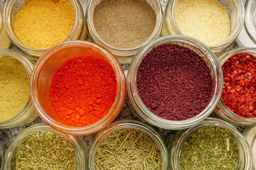Assorted seasoning spice in the jars in the kitchen close up view
