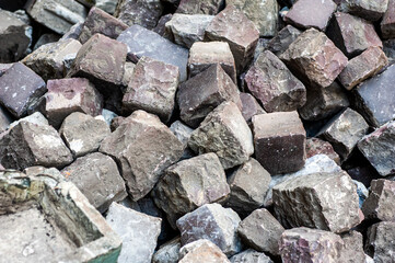 Many old cobblestones from the road are stacked
