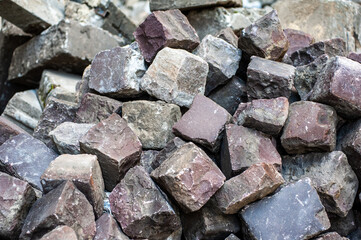 Many old cobblestones from the road are stacked