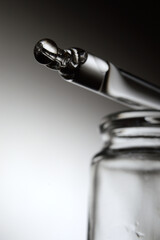 pipette and cosmetic bottle on a gray gradient background. close-up.