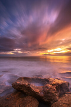 An ethereal sky reflecting off the incoming tide on a stretch of rocky Atlantic coast.
