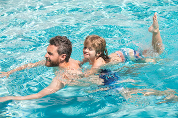 Father and son swimming in pool, summer family holidays. Dad and son in pool. Swimming lessons. Fathers Day. Family weekend.