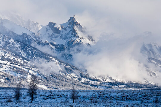 Teewinot Peak pokes out from clearing fog from a wintery spring storm in Grand Teton National Park, Wyoming.