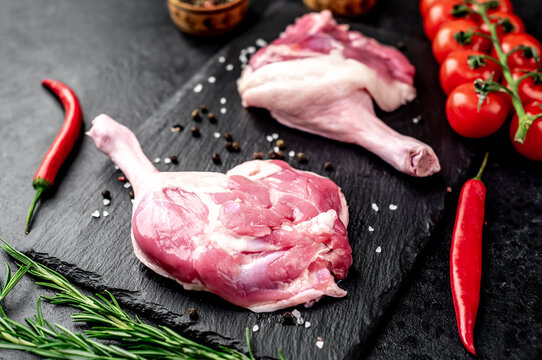 raw duck leg with spices on a stone background