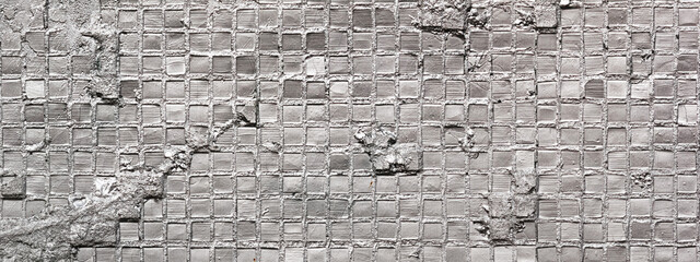 Abstract tiled wall, horizontal background, banner, in the form of a rough damaged old wall, closeup