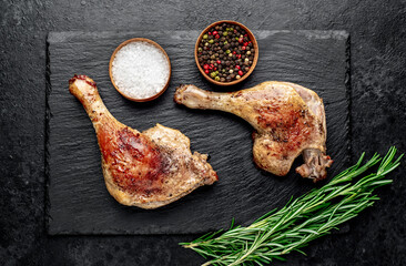 Roasted duck leg with spices on a stone background