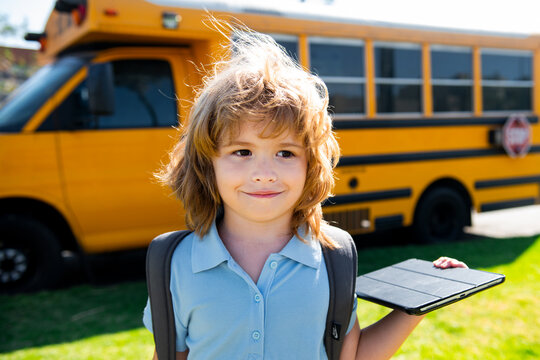 Pupil Kid With Tablet Near School Bus. Social Distance During Quarantine, On-line Education Concept, Homeschool Outside.