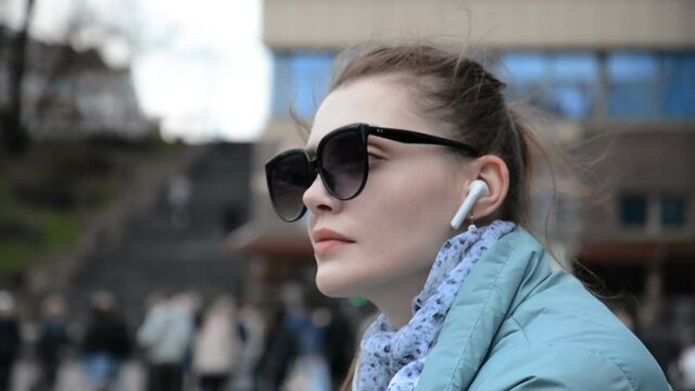 Hipster caucasian girl portrait in sunglasses having fun and listens to music in the headphones